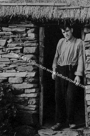 MAN AT DOOR OF COTTAGE